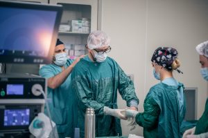 Medical professionals prepare for surgery in a hospital operating room, showcasing teamwork and precision.
